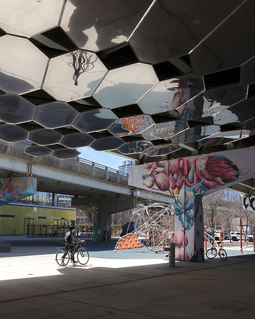 An underpass featuring street art and a reflective ceiling
